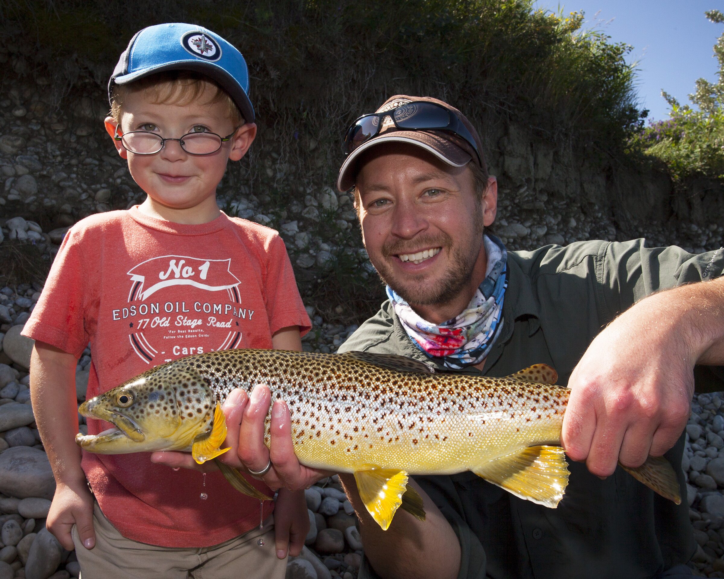 Man holding a fish with young boy