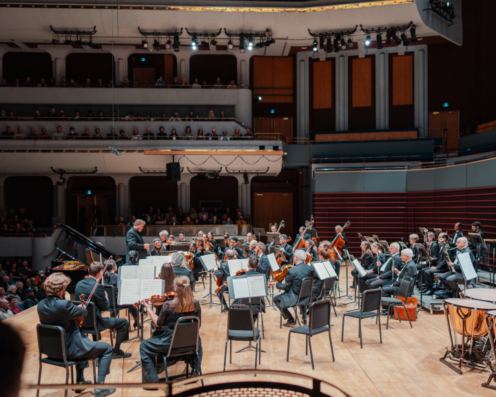 a full crowd of spectators enjoying a performance by the Calgary Philharmonic Orchestra