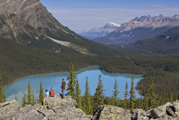Group of three people sitting on rocks looking at Peyto Lake in Banff National Park along the Icefields Parkway