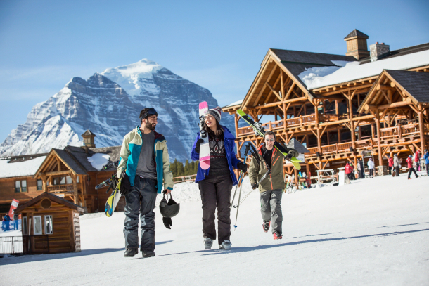 friends walking to the lodge with their skis at Lake Lousie