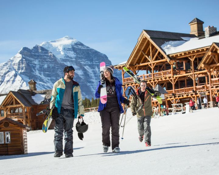 friends walking to the lodge with their skis at Lake Lousie