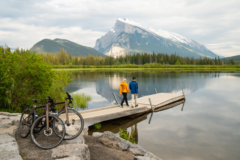 Couple walking on dock after riding bikes at Vermillion Lakes in Banff
