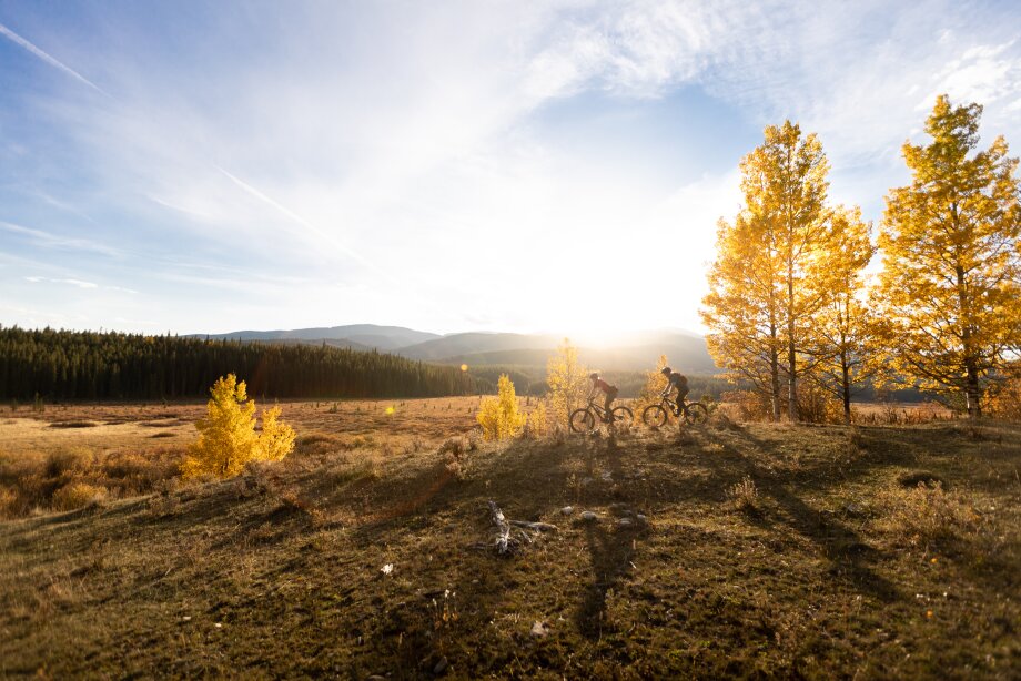 Two people mountain biking on a beautiful fall day near Bragg Creek.