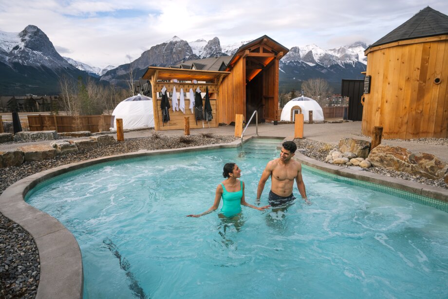 A couple bathe in a nordic pool at Everwild Canmore - Nordic Spa & Hotel.