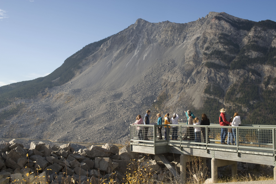 A group of visitors at a lookout point observing Frank Slide in the Crowsnest Pass
