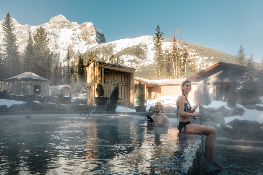 Snow scene with a couple at the Nordic Spa at the Pomeroy Kananaskis Mountain Lodge