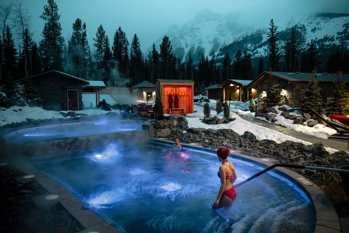 Scenic night shot of a couple enjoying hot tub at Nordic spa at the Pomeroy Kananaskis Mountain Lodge