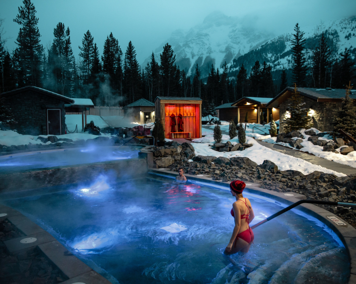 Scenic night shot of a couple enjoying hot tub at Nordic spa at the Pomeroy Kananaskis Mountain Lodge