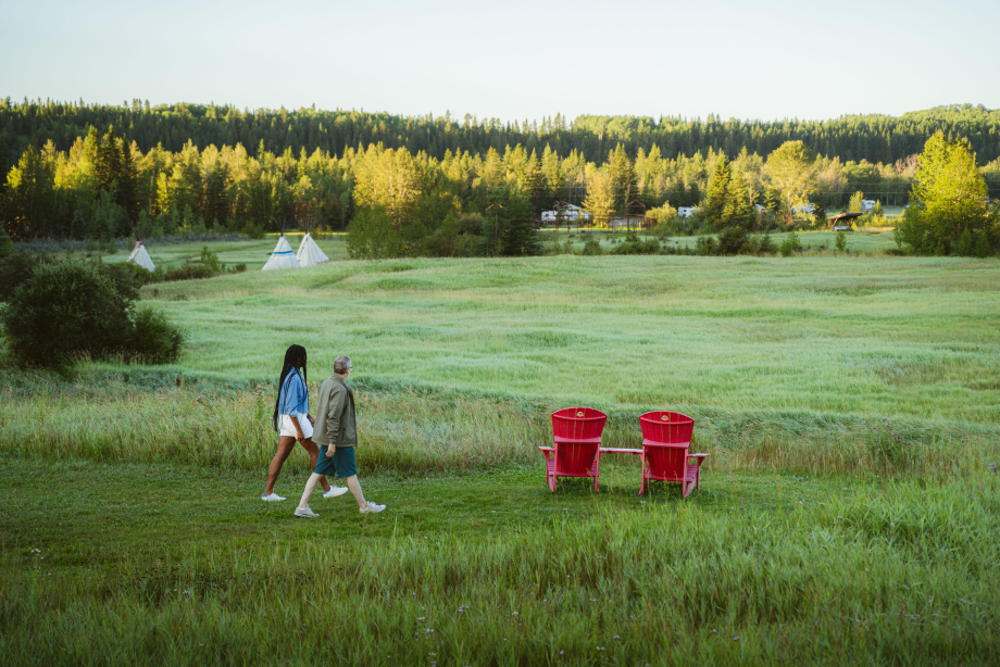 Two people walk towards red chairs at Rocky Mountain House National Historic Site