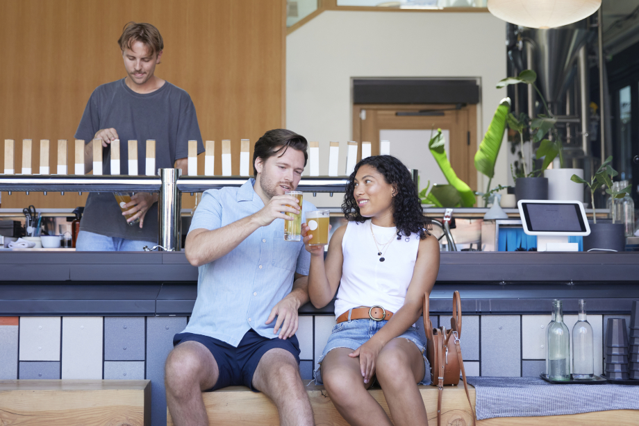 Couple enjoying pints of beer at 33 Acres Brewing Co in Calgary's beltline