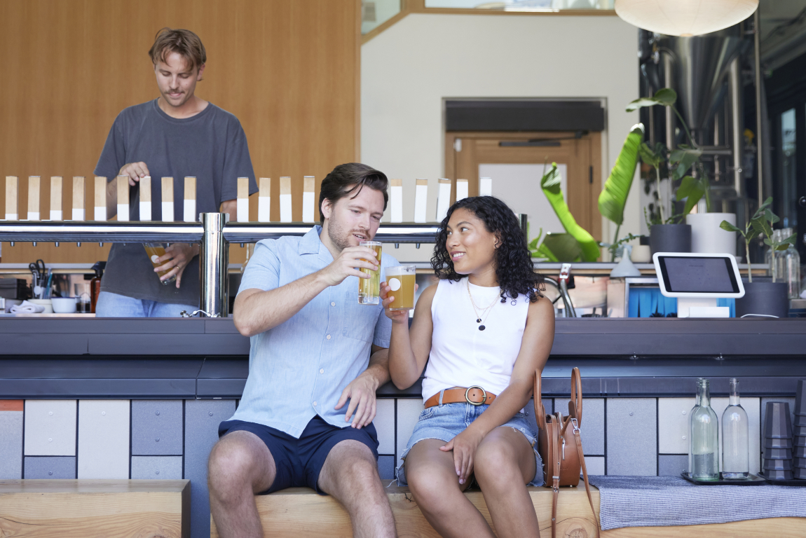 Couple enjoying pints of beer at 33 Acres Brewing Co in Calgary's beltline