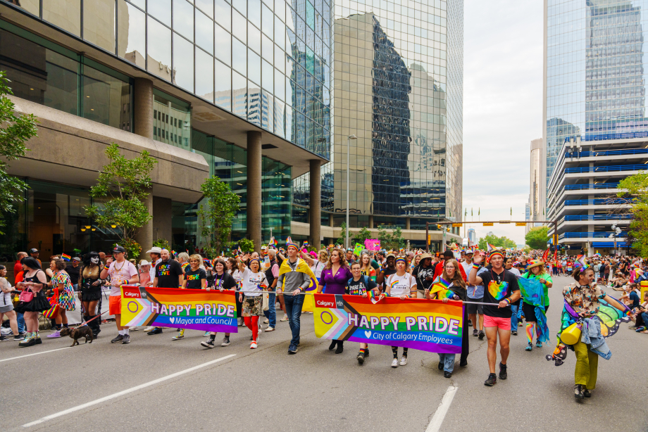 Colourful setting with pride colours and people participating in the Calgary Pride Parade in downtown