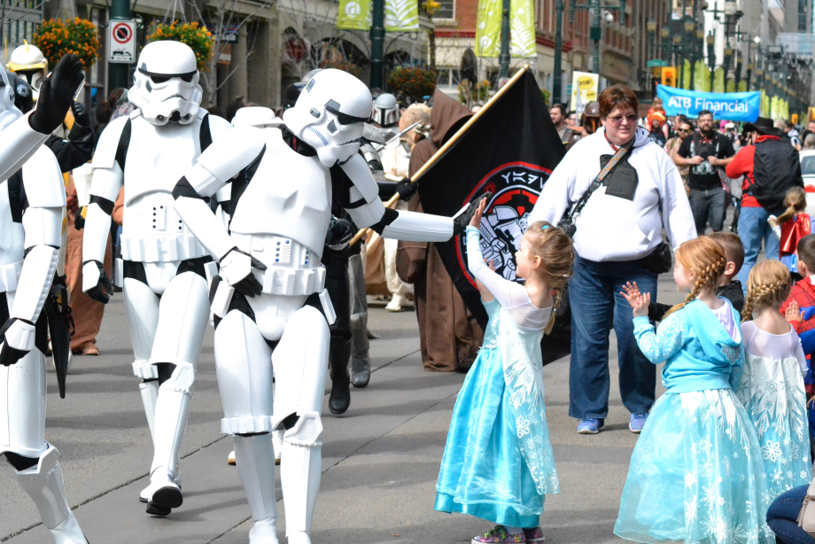 Girl in Elsa costume high-fiving a character.