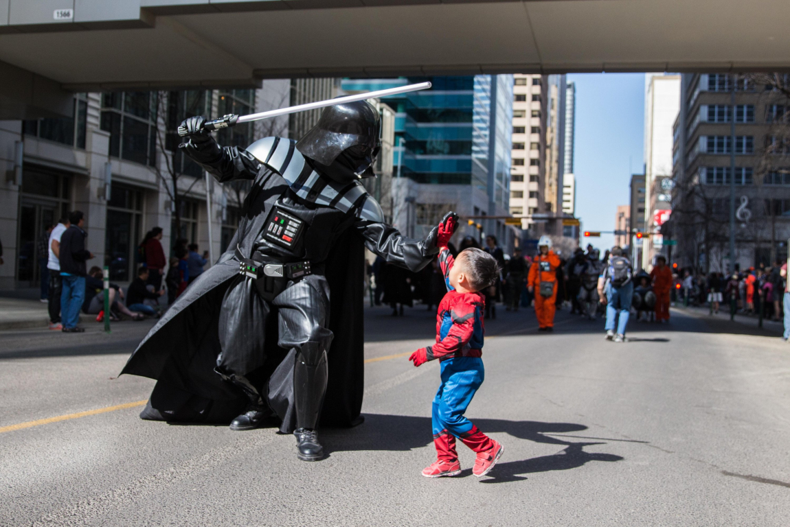 Darthvader and little boy dressed as spiderman high fiving