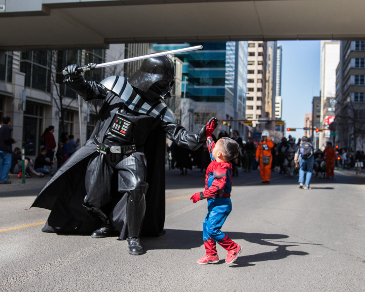 Darthvader and little boy dressed as spiderman high fiving