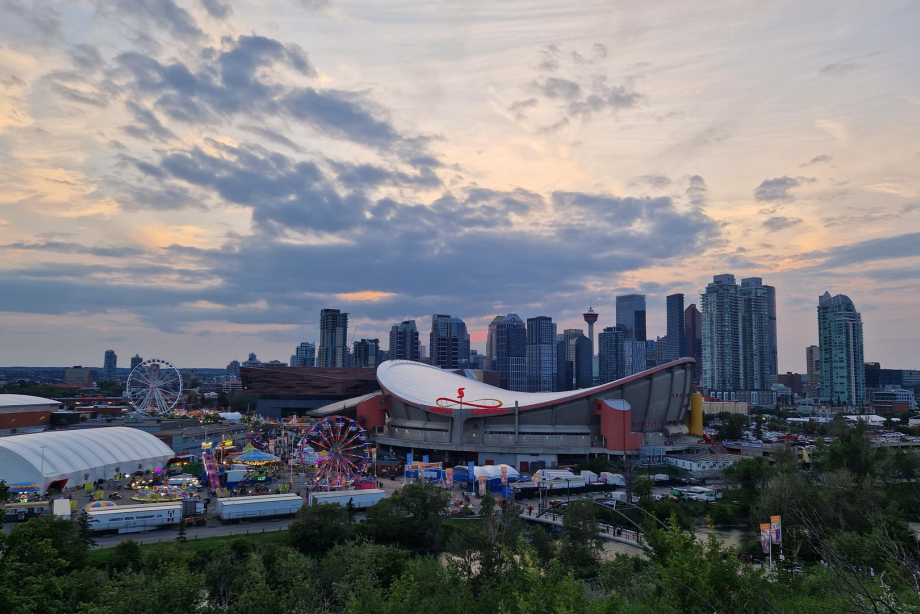 Calgary Stampede ground with Saddledome and downtown buildings in the background at dusk