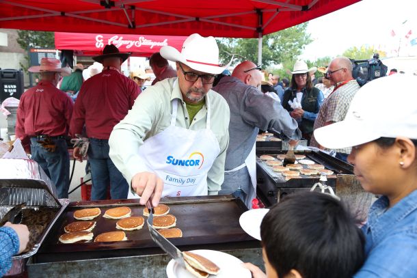Man serving and flipping pancakes on grill