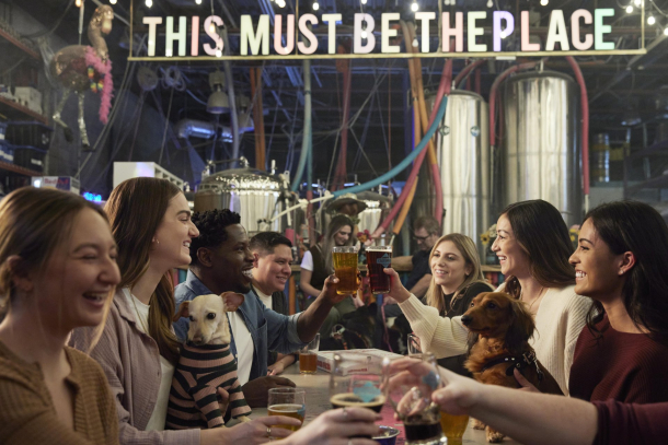 group of friends cheers pint glasses inside Cold Garden's taproom