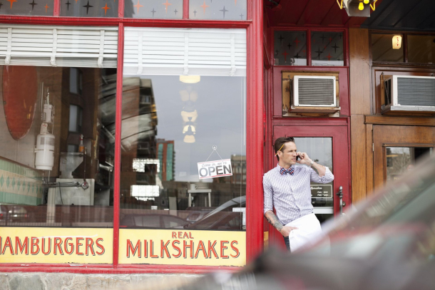 server stands outside Galaxie Diner's vintage exterior