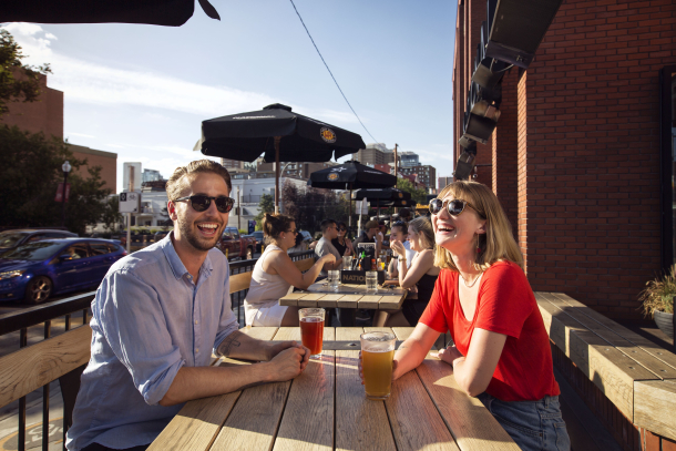 Couple having drinks on the patio at the National on 17th Street in Calgary