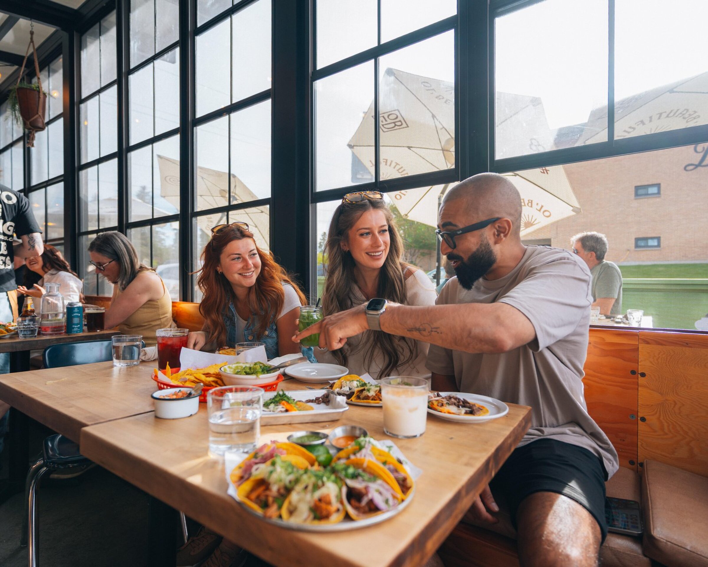 Three friends eating tacos at Native Tongues.
