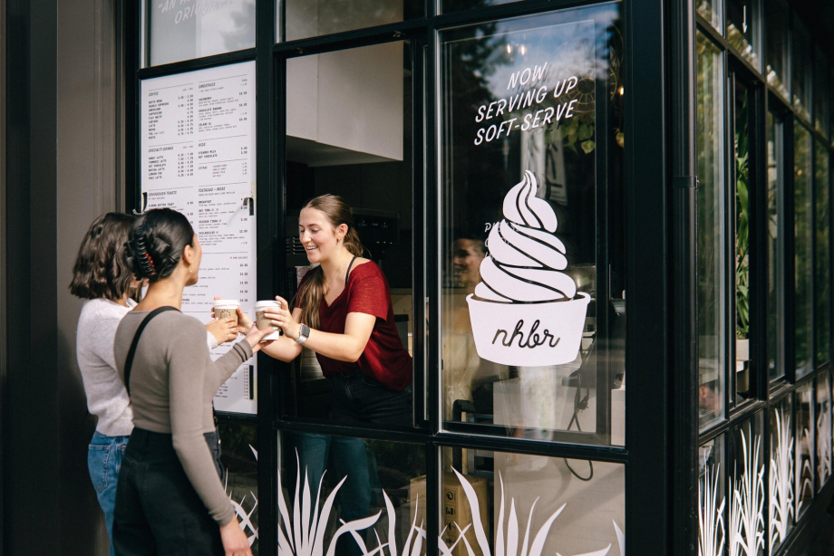 barista serves two ladies coffee from a takeout window at NHBR coffee