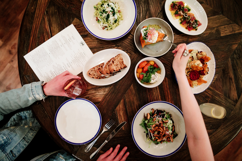 Stylized aerial food shot of plates of food at a restaurant in Calgary