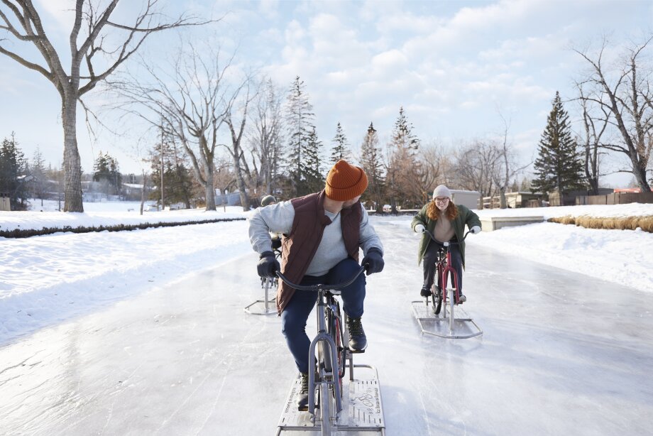 Two people ice biking on a frozen lagoon in Bowness Park