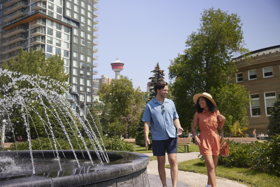 Couple walking around the fountain at Central Memorial Park downtown Calgary