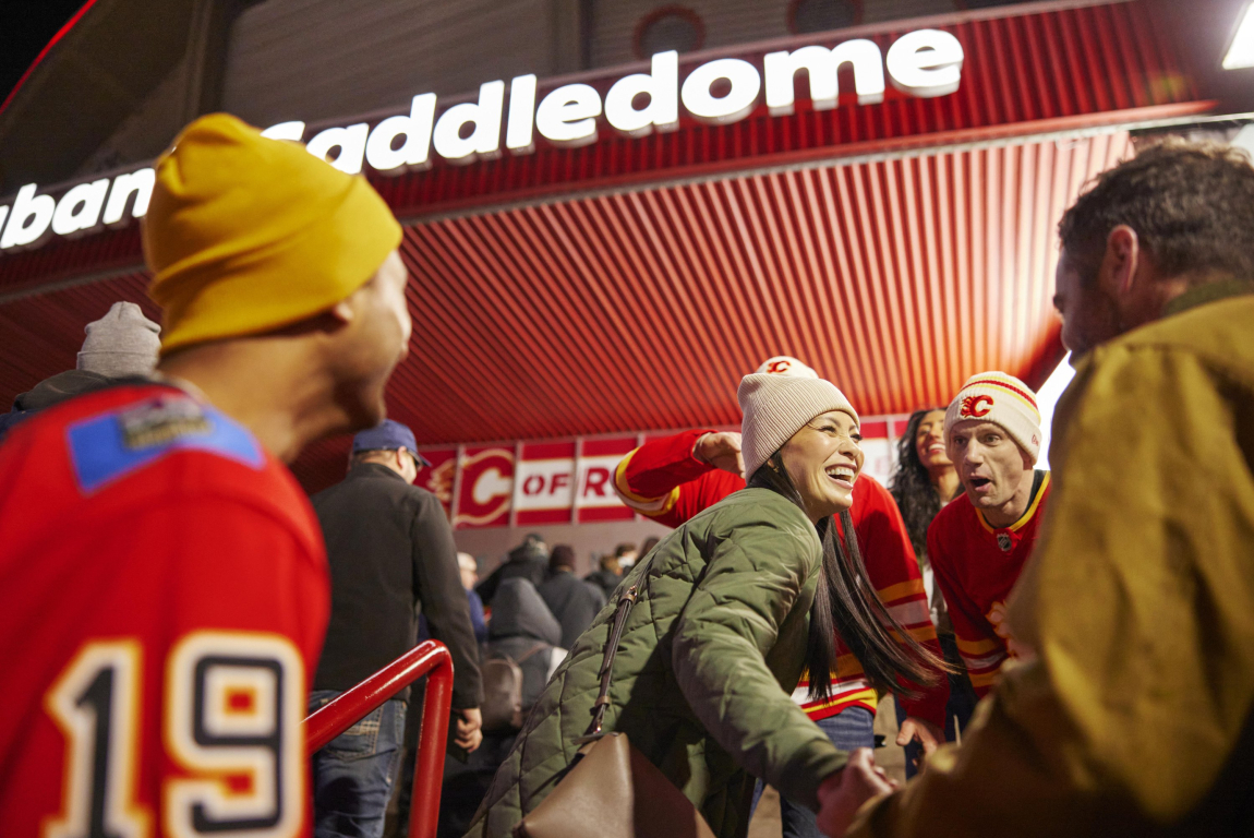 Friends dressed up in Calgary Flames gear heading to a hockey game at the Saddledome