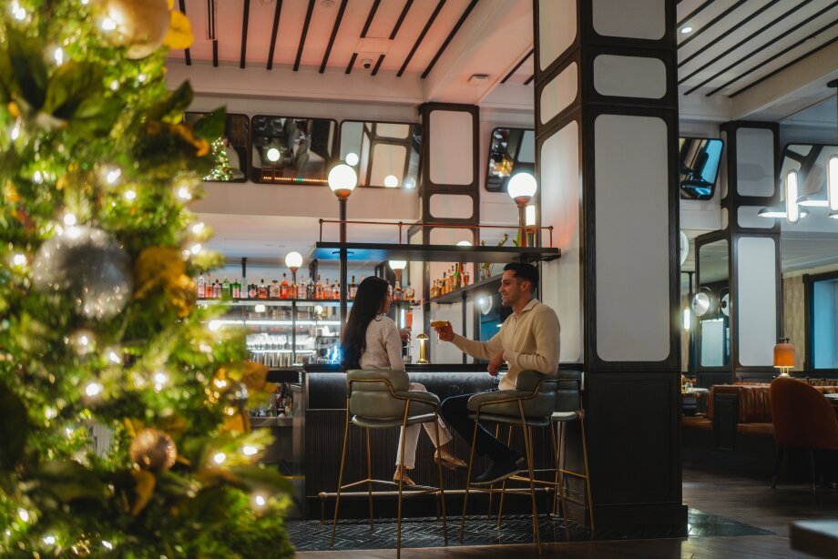 Couple sitting at a bar at in the lobby of Fairmont Palliser hotel