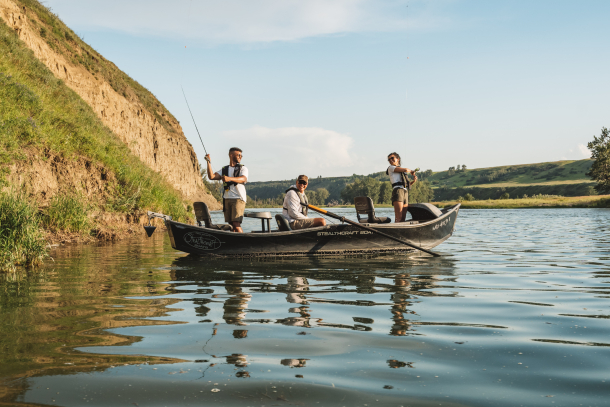 People fishing off a boat in the Bow River
