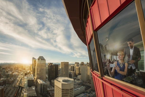 Couple having dinner at Sky 360 Restaurant with views of the city skyline from the Calgary Tower