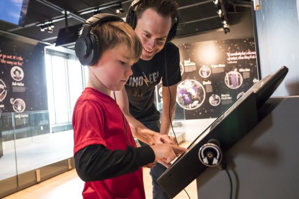 father and son exploring a music exhibit at Studio Bell.