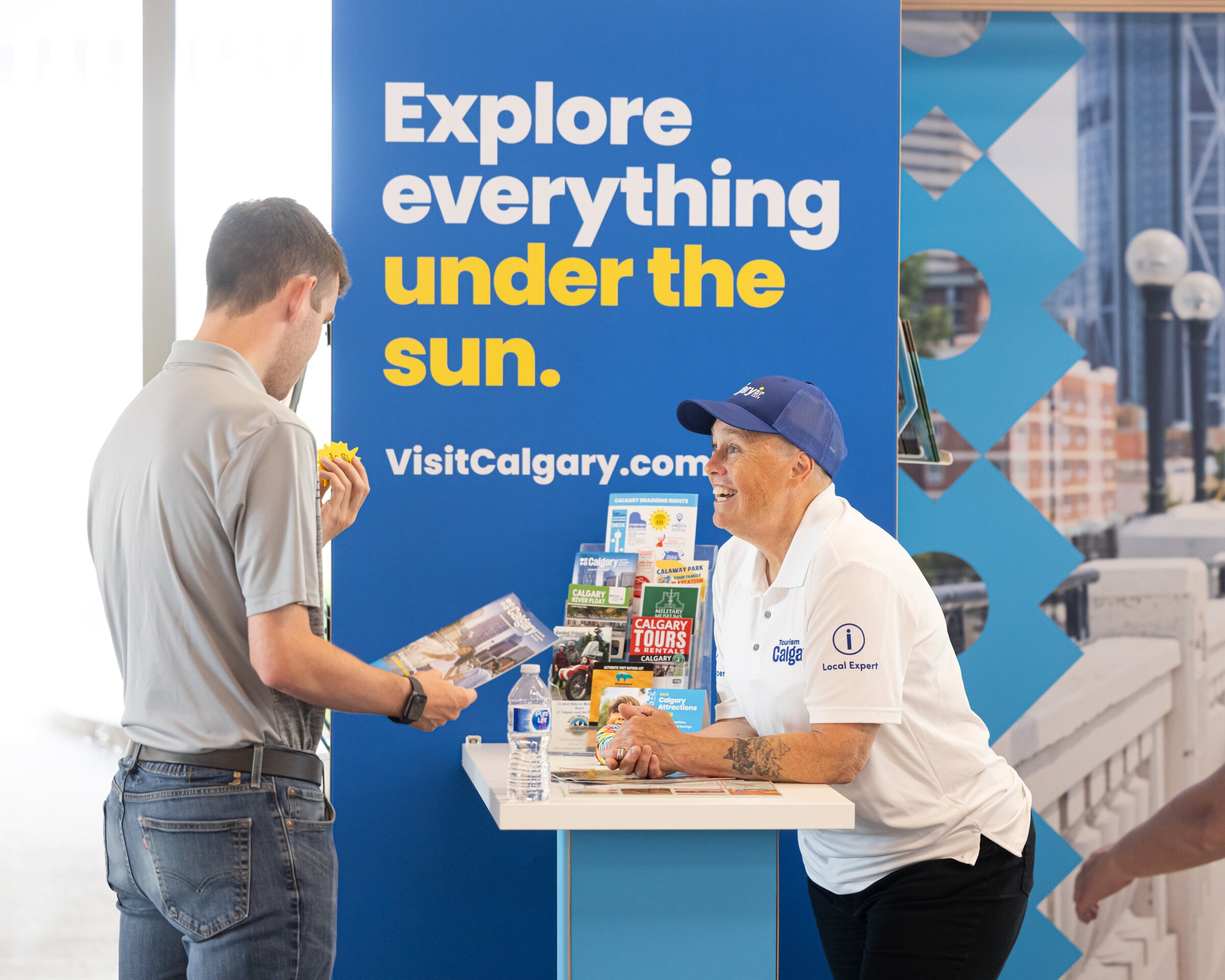 A Tourism Calgary local expert helps a guest with a visitor guide.