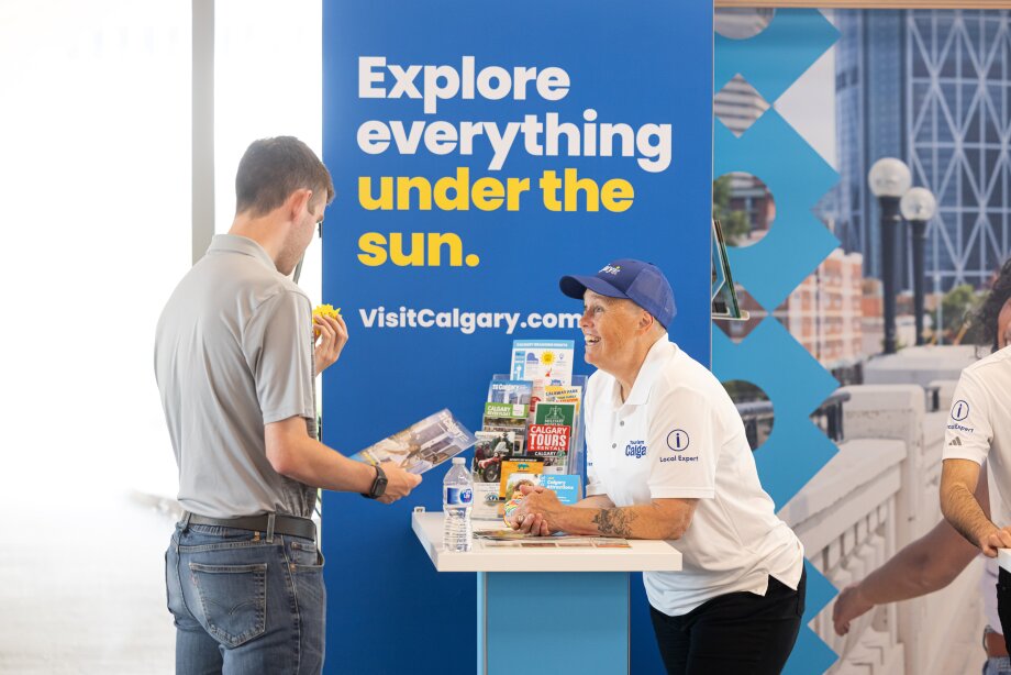 A Tourism Calgary local expert helps a guest with a visitor guide.