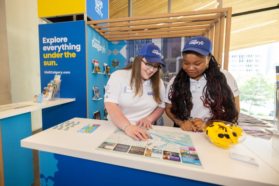Two Tourism Calgary local experts point out spots on a visitor map.