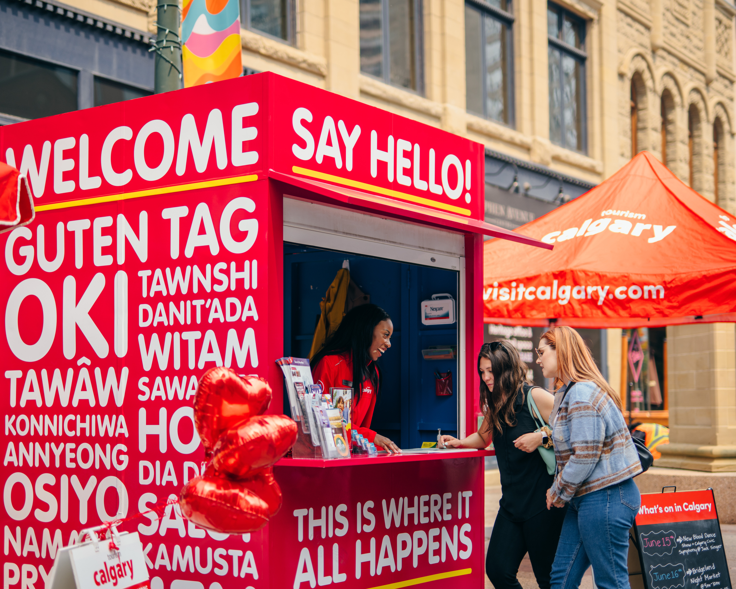 A travel counsellor on Stephen Avenue helps two visitors plan their trip.