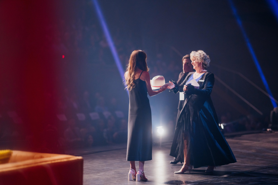 Presenting a white hat award on a big stage