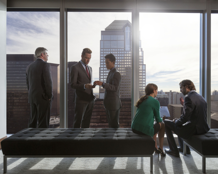 Group of business people at the window of an office tower with views of downtown Calgary, Alberta