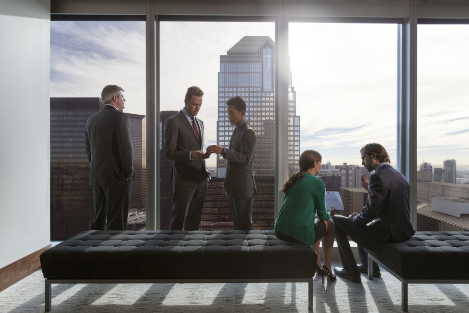 Group of business people at the window of an office tower with views of downtown Calgary, Alberta