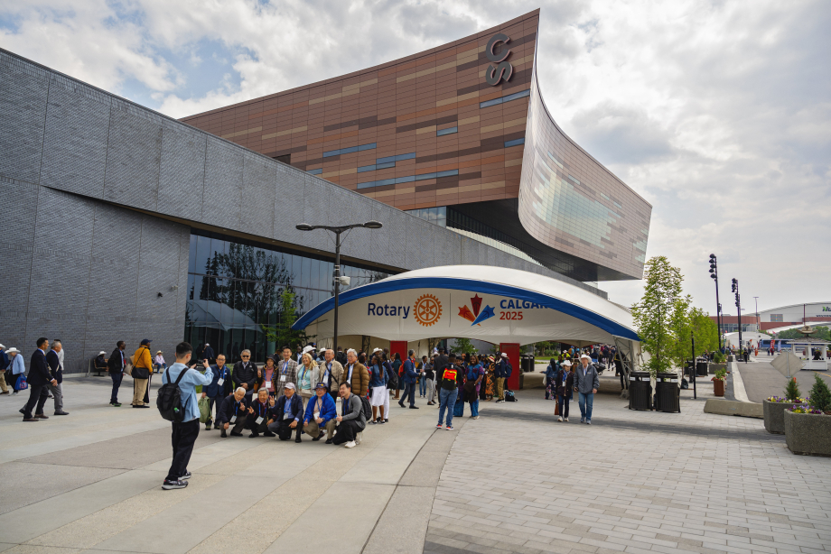 Group of Rotary attendees posing for a photo in front of a large entrance gate