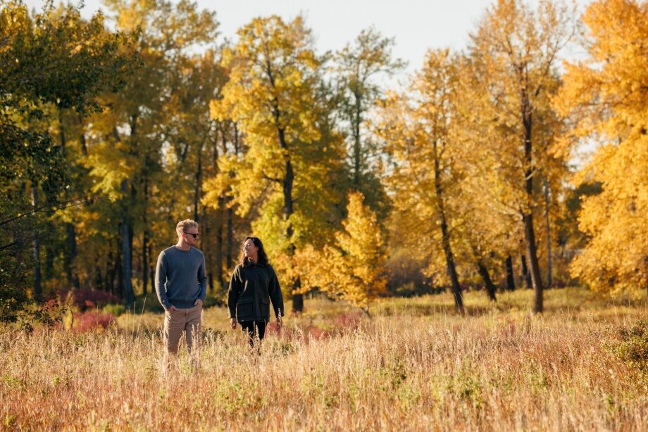 A couple walks through Carburn Park on a beautiful fall day.