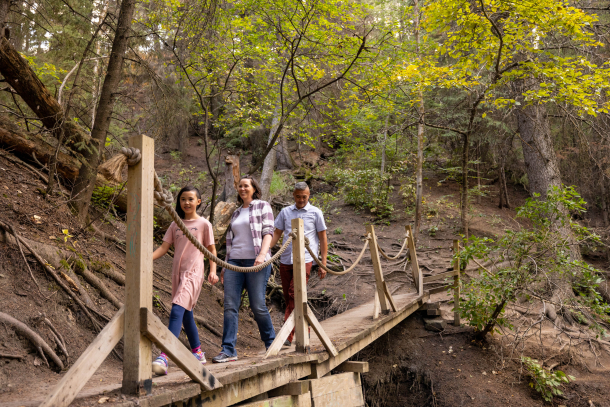 family hiking along a wooden bridge in the woods of the Douglas Fir trail