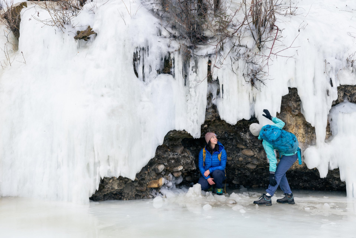 two ladies explore ice formations during winter in Fish Creek Provincial Park