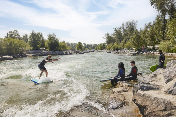 Group of friends surfing in a river