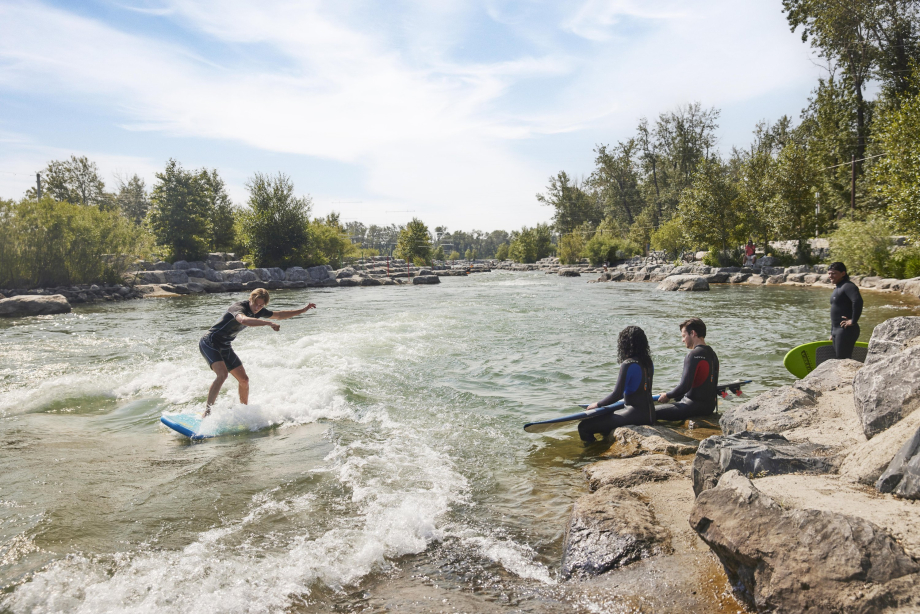 Group of friends surfing in a river