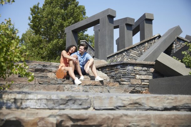 A couple sits on some steps near Harvie Passage.