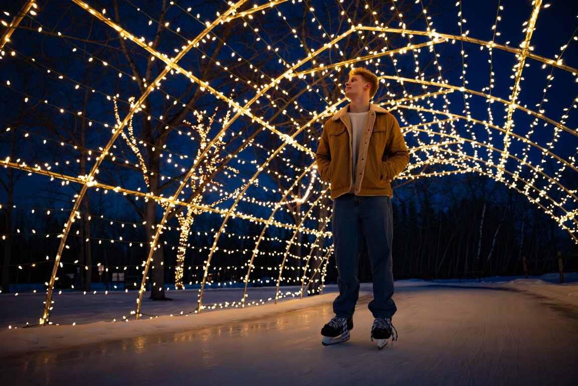 Man ice skating under lights at the North Glenmore Park