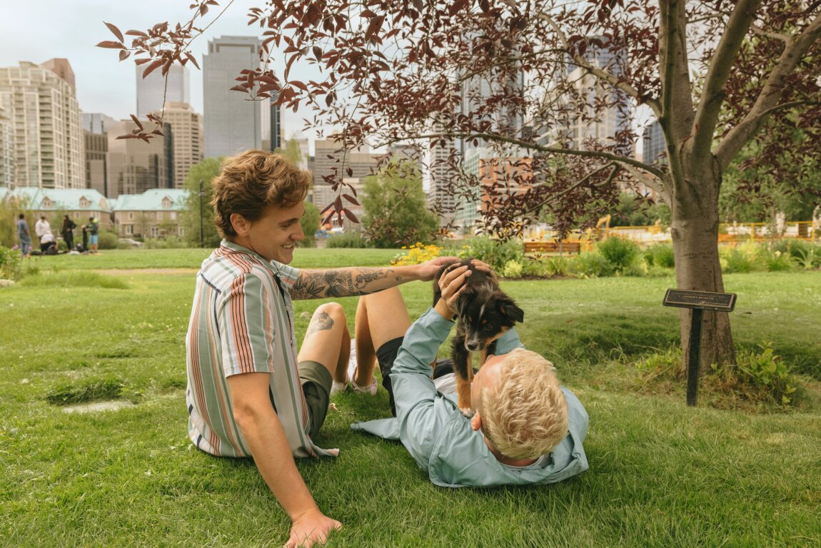 A couple playing with a dog at Prince's Island Park.